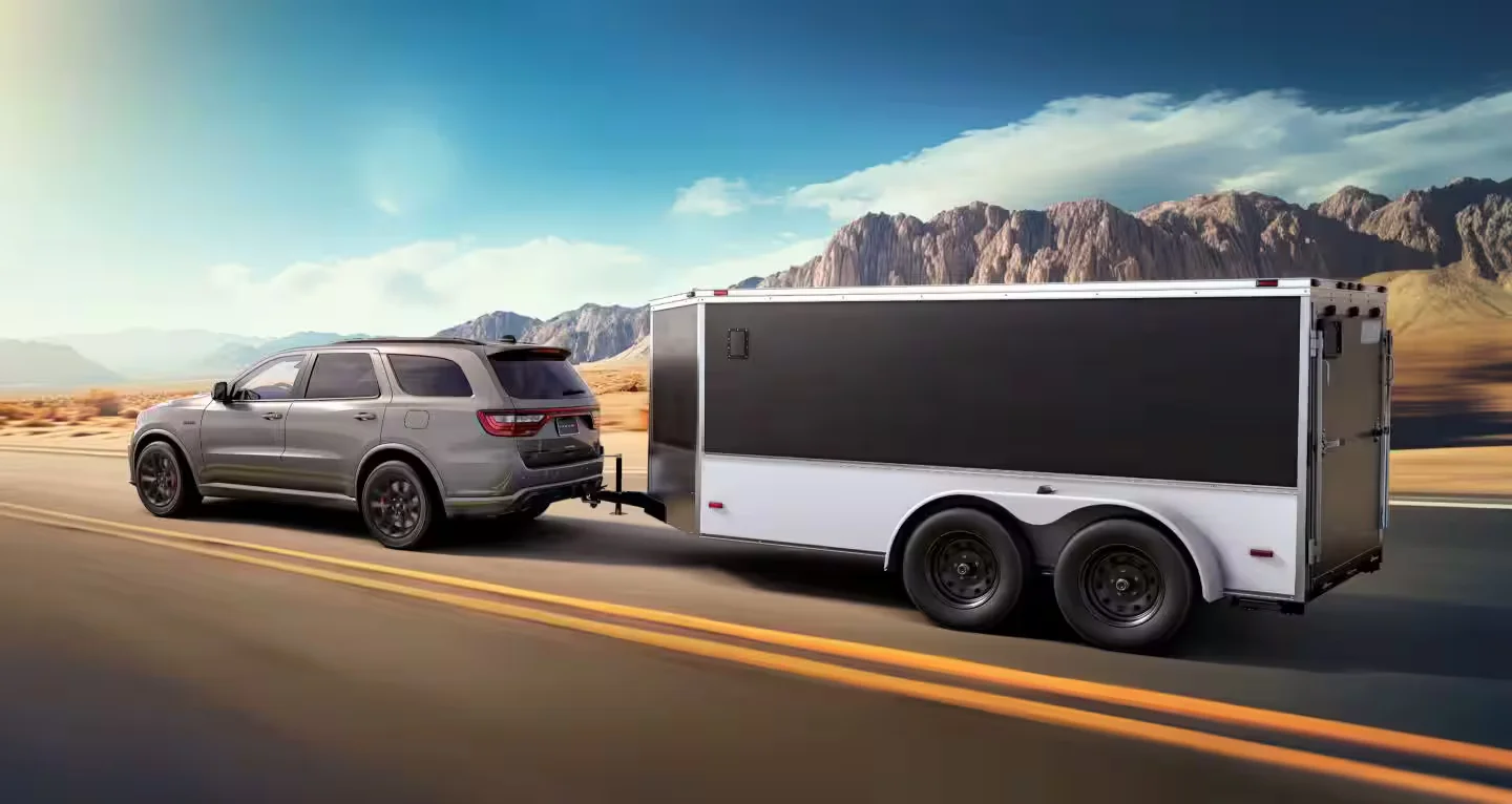 2026 Dodge Durango towing an enclosed trailer on a desert highway to highlight capability